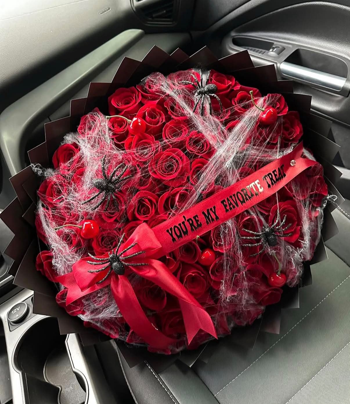 Halloween bouquet of red roses with spiderwebs and a You’re My Favorite Treat ribbon